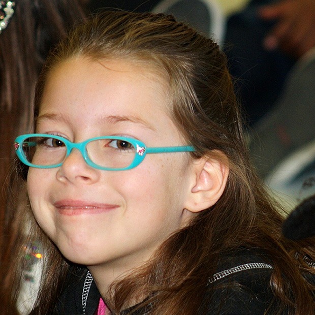 Young girl with blue green glasses, smiling