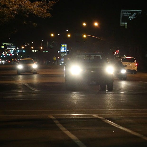 Picture of cars driving at night with headlights on