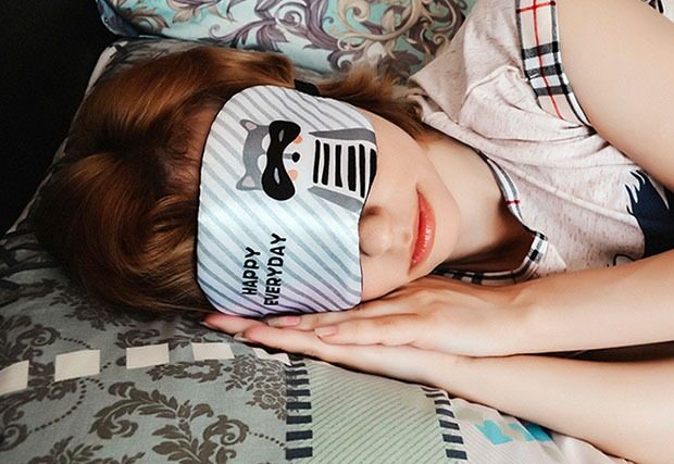 Young woman sleeping with eye mask over her eyes