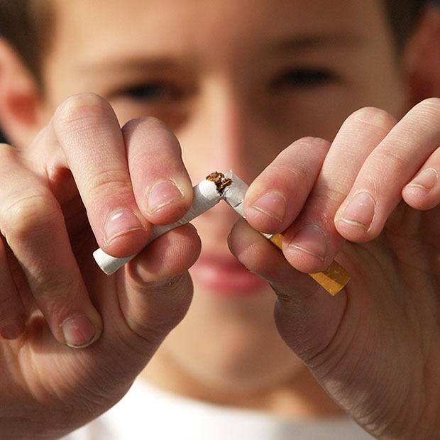 Closeup shot of young person destroying a cigarette close to screen