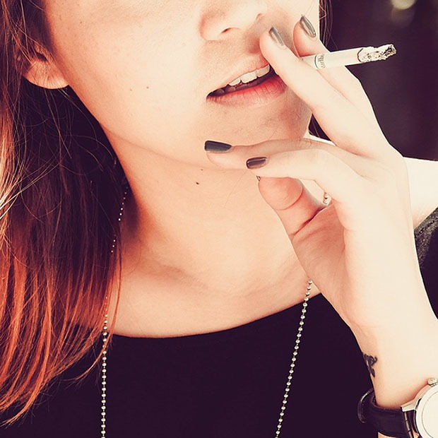 Closeup shot of young woman with a cigarette close to mouth