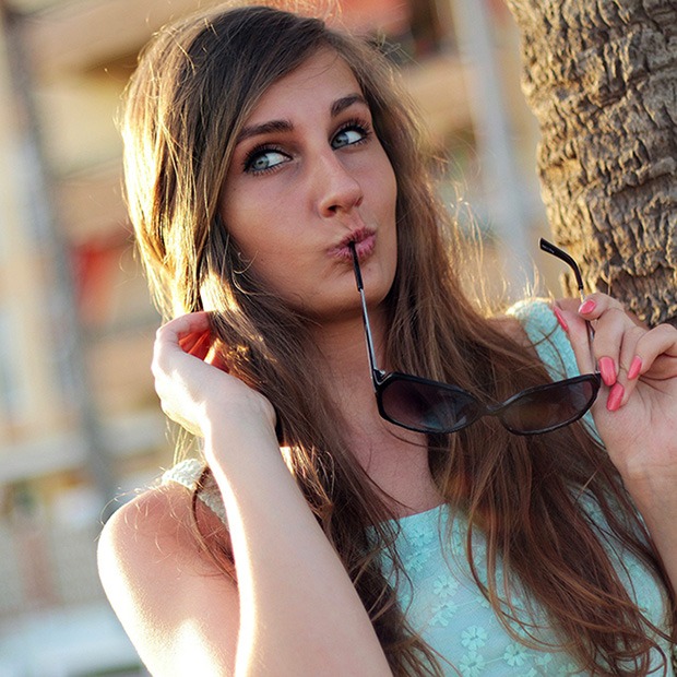 Young adult woman posing with sunglasses