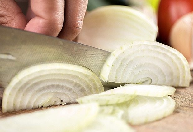 Close up shot of person chopping onions