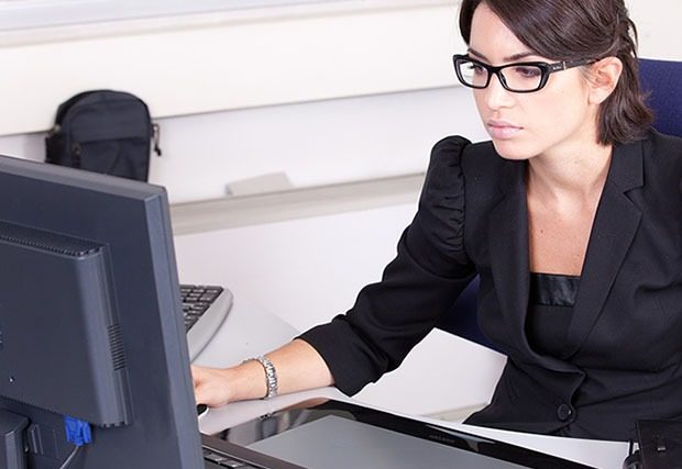 Young woman at work in office with black glasses