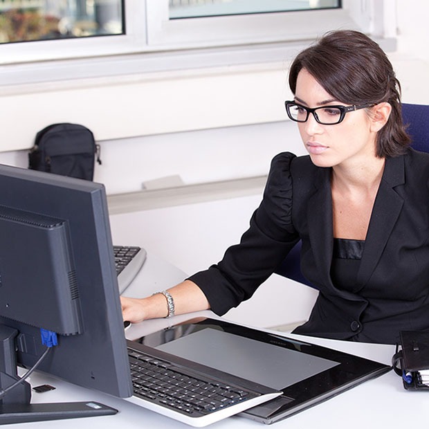 Young woman at work in office with black glasses