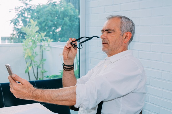 mature man with mobile phone and presbyopia