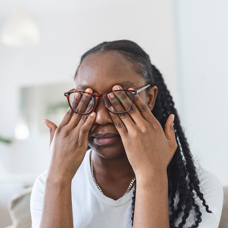 African girl in glasses rubs her eyes, suffering from tired eyes, ocular diseases concept