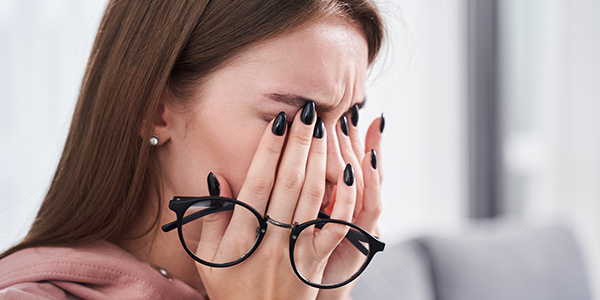 Woman rubbing dry irritated eyes