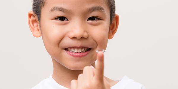 Young Boy Holding Contacts on his finger