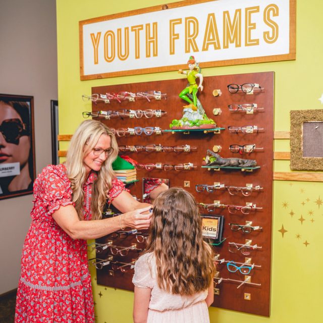 optometrist fitting young girl with eyeglasses