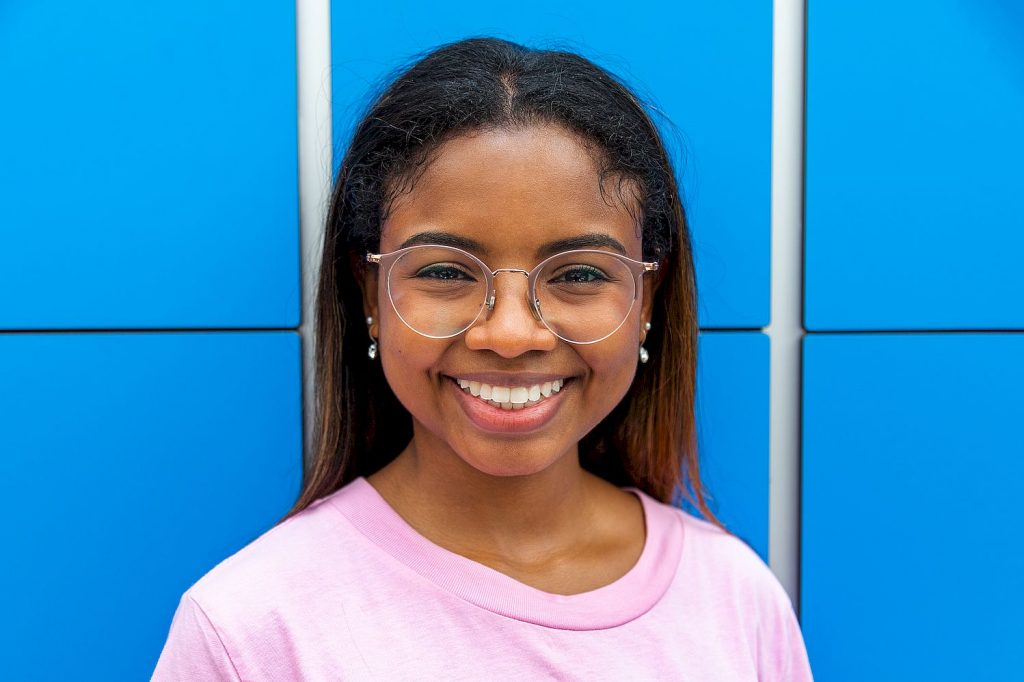 Portrait of happy teen african latina female high school student looking at camera wearing glasses. Education.