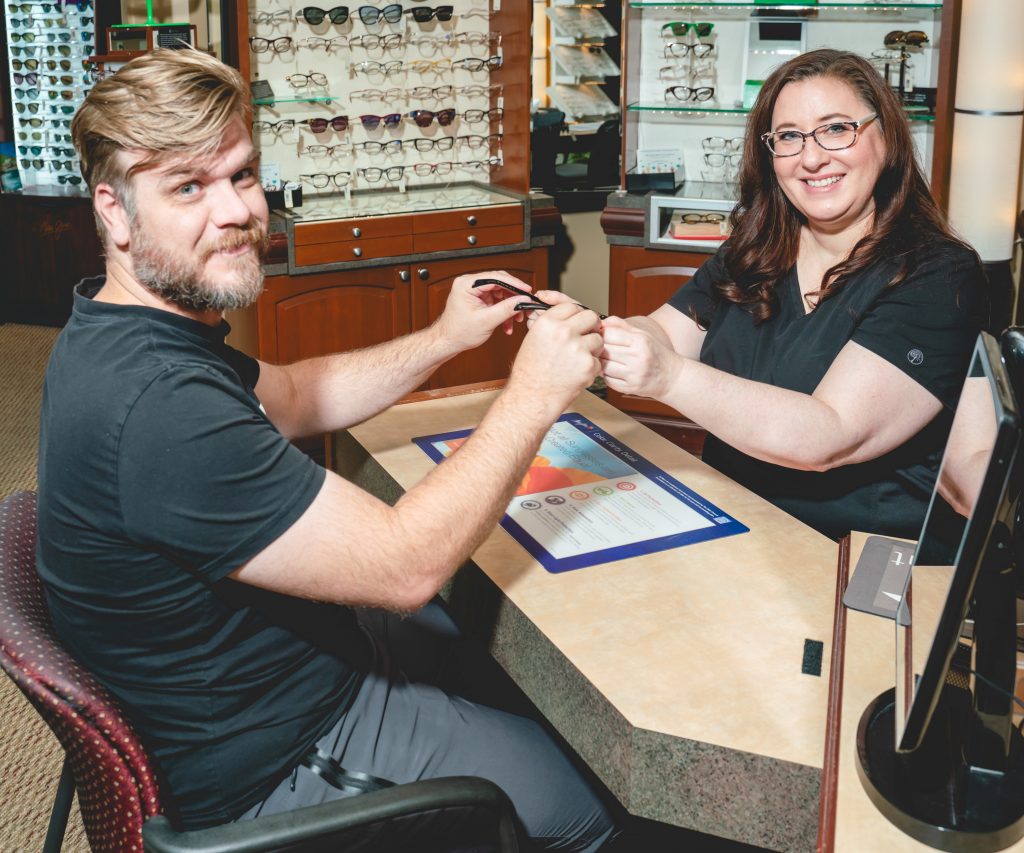 optician helping man select eyeglasses