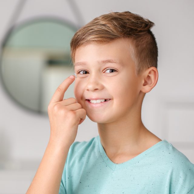 boy holding contact lens on finger 640x640