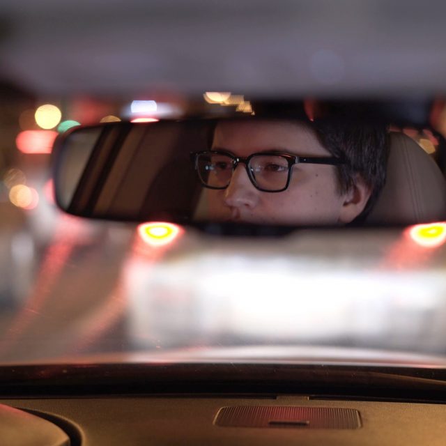drivers face reflected in rear view mirror