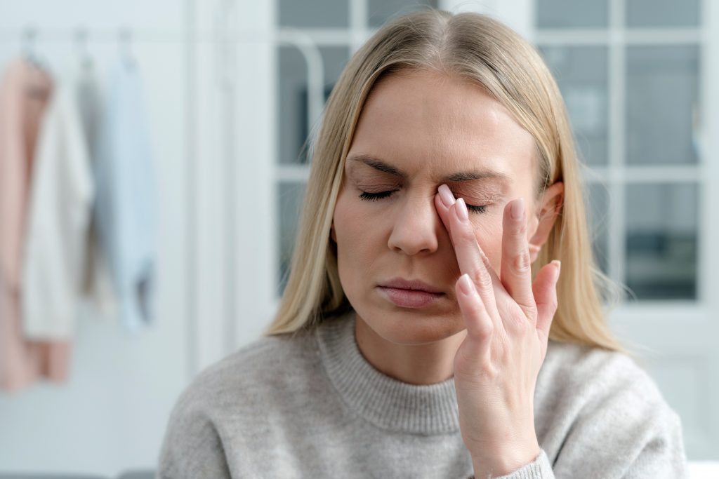 woman closing irritaed dry eyes