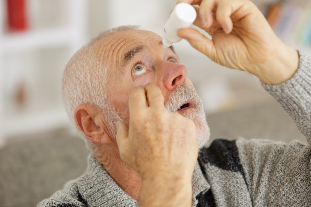 senior man using glaucoma drops
