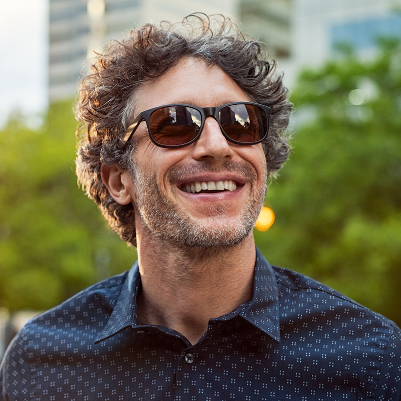 smiling gentleman wearing designer sunglasses