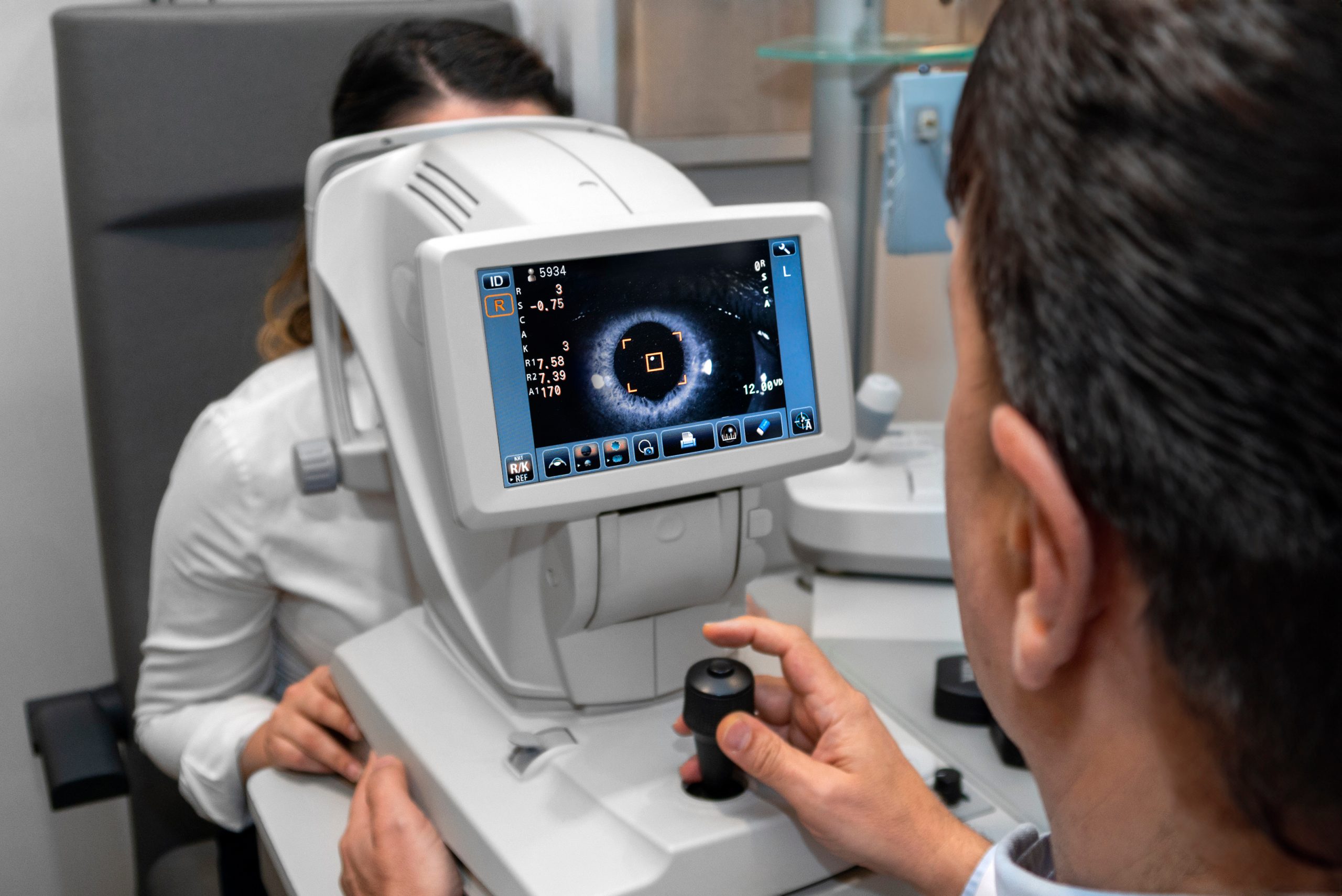 Lady looking at refractometer eye testing machine in ophthalmology, tonometer