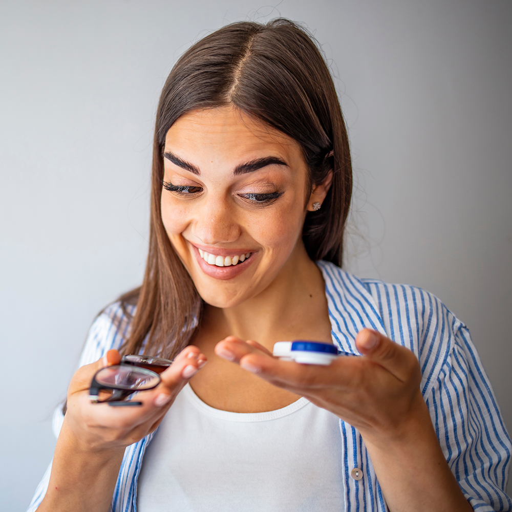 Young Hispanic Woman choosing between contact lens optionsand eyeglasses