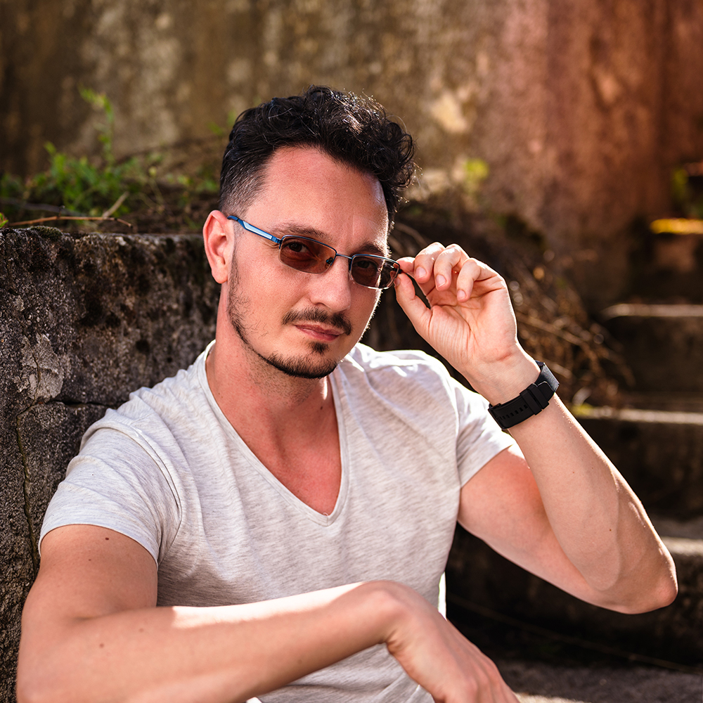 Young Latin Man wearing transitions lenses sitting on stairs