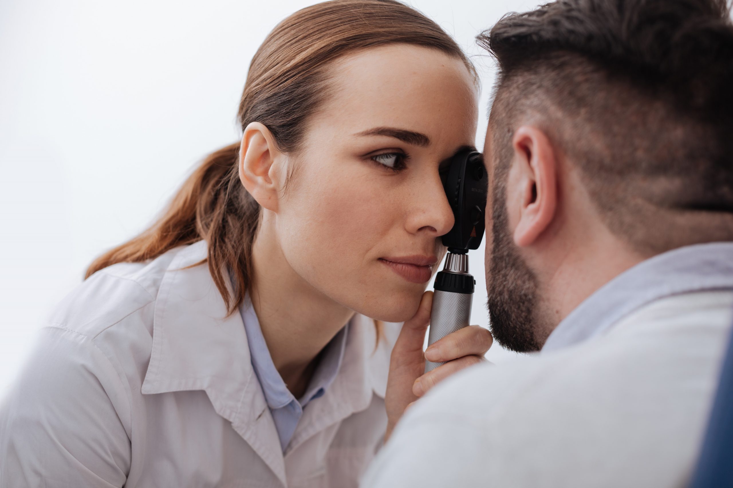 Pleasant pretty woman holding an ophthalmoscope