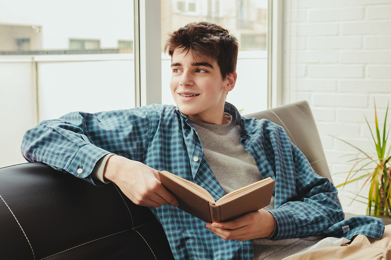 teen reading on couch