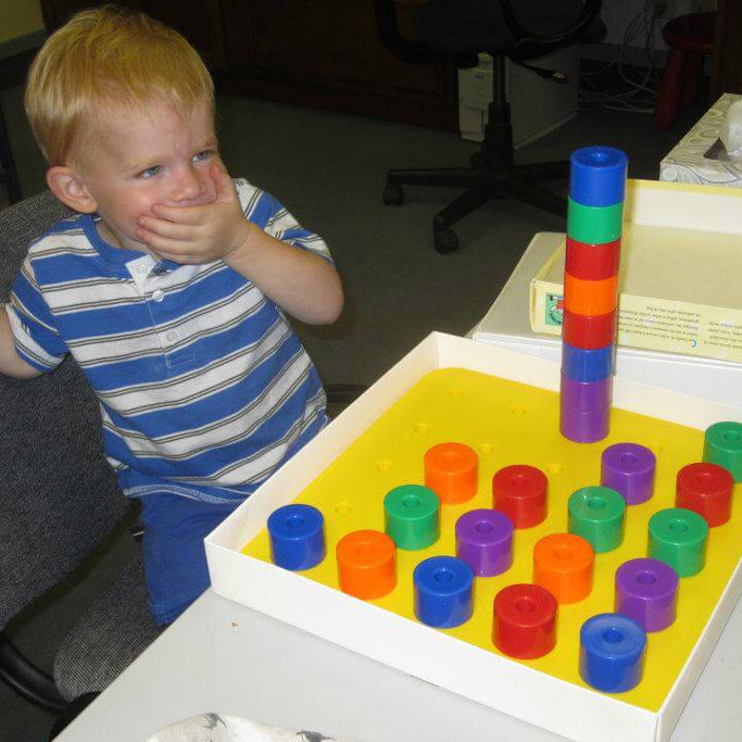 boy doing vision therapy with pegboard in Boulder, Colorado