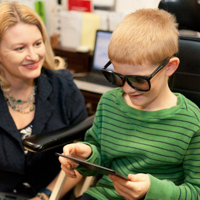 boy doing vision therapy with doctor