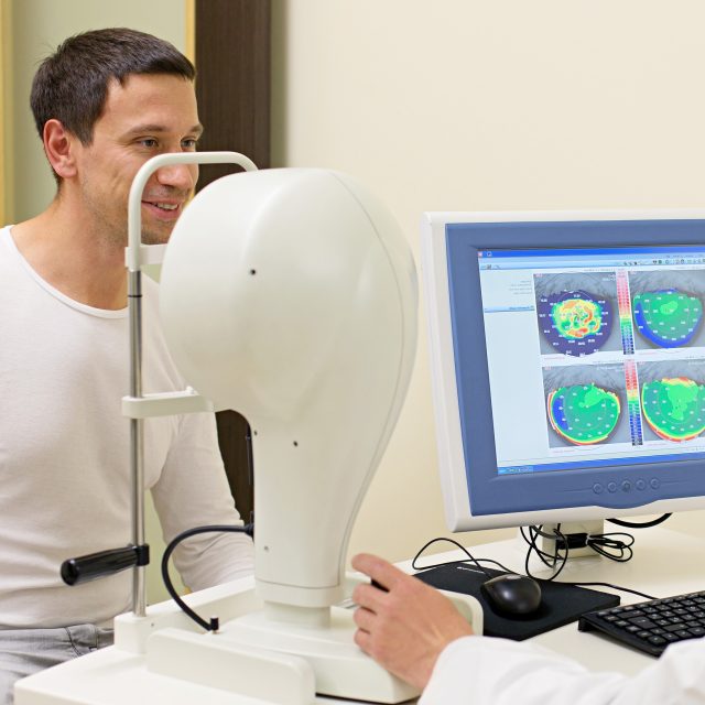 man sitting at corneal scanning equipment rev