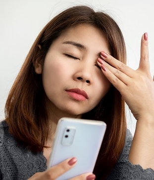 woman with eye pain calling her optometrist