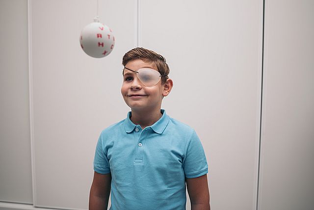 A child undergoes vision therapy in an optician. Marsden ball.