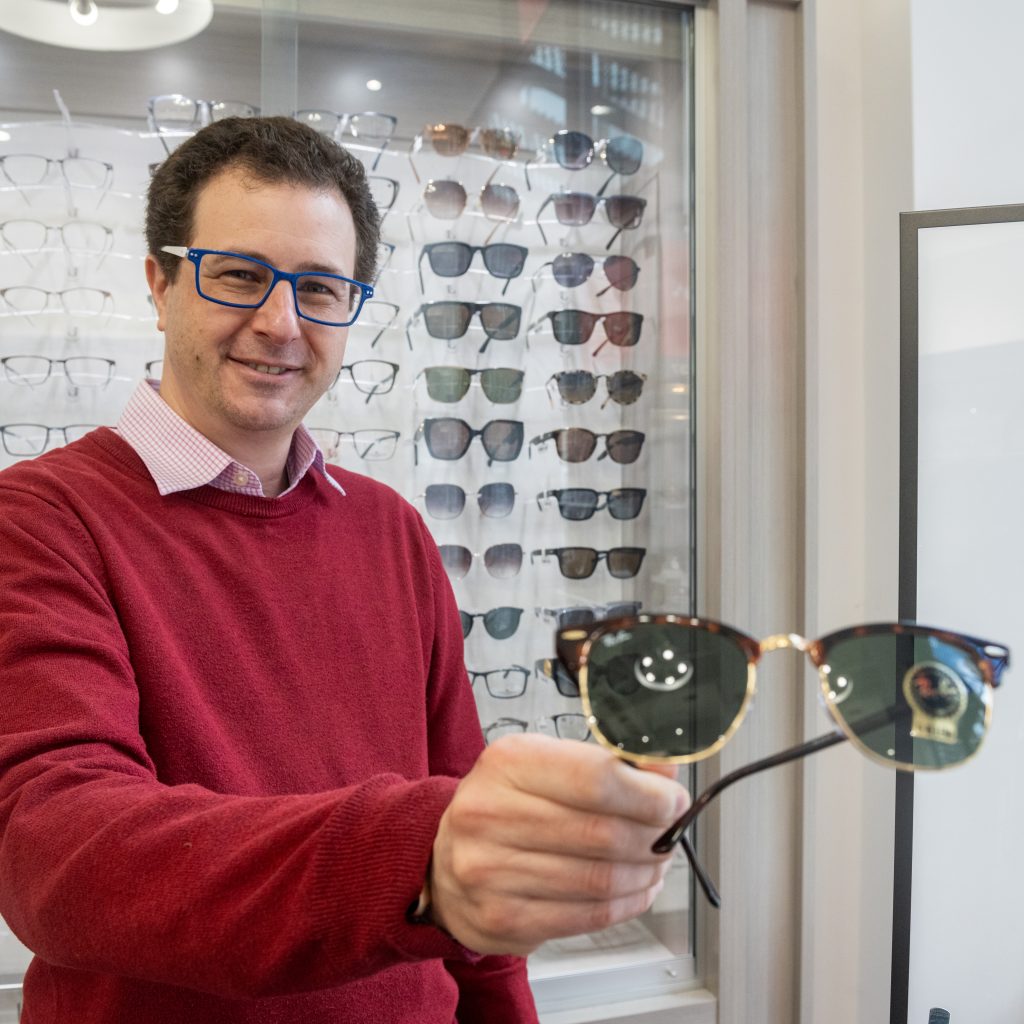optician holding Ray Ban sunglasses