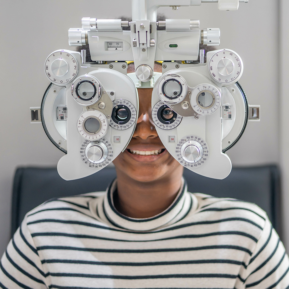Close up Of african teen girl Doing Eye Test On Phoropter