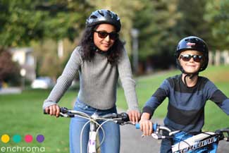 Happy mother and son riding bicycles and wearing Enchroma Glasses