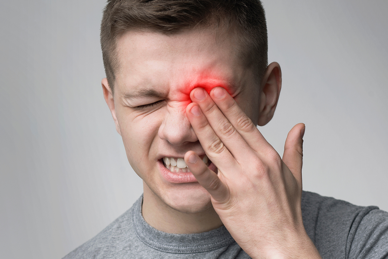 Upset man suffering from strong eye pain