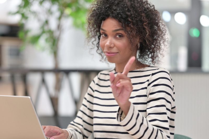 woman on laptop saying no by finger sign