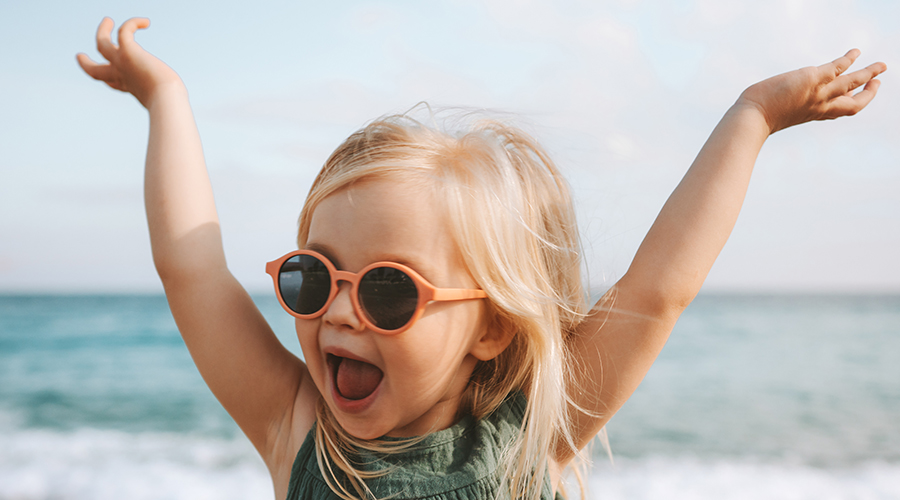 Funny kid girl playing outdoor surprised emotional child in sunglasses 3 years old baby raised hands family vacations