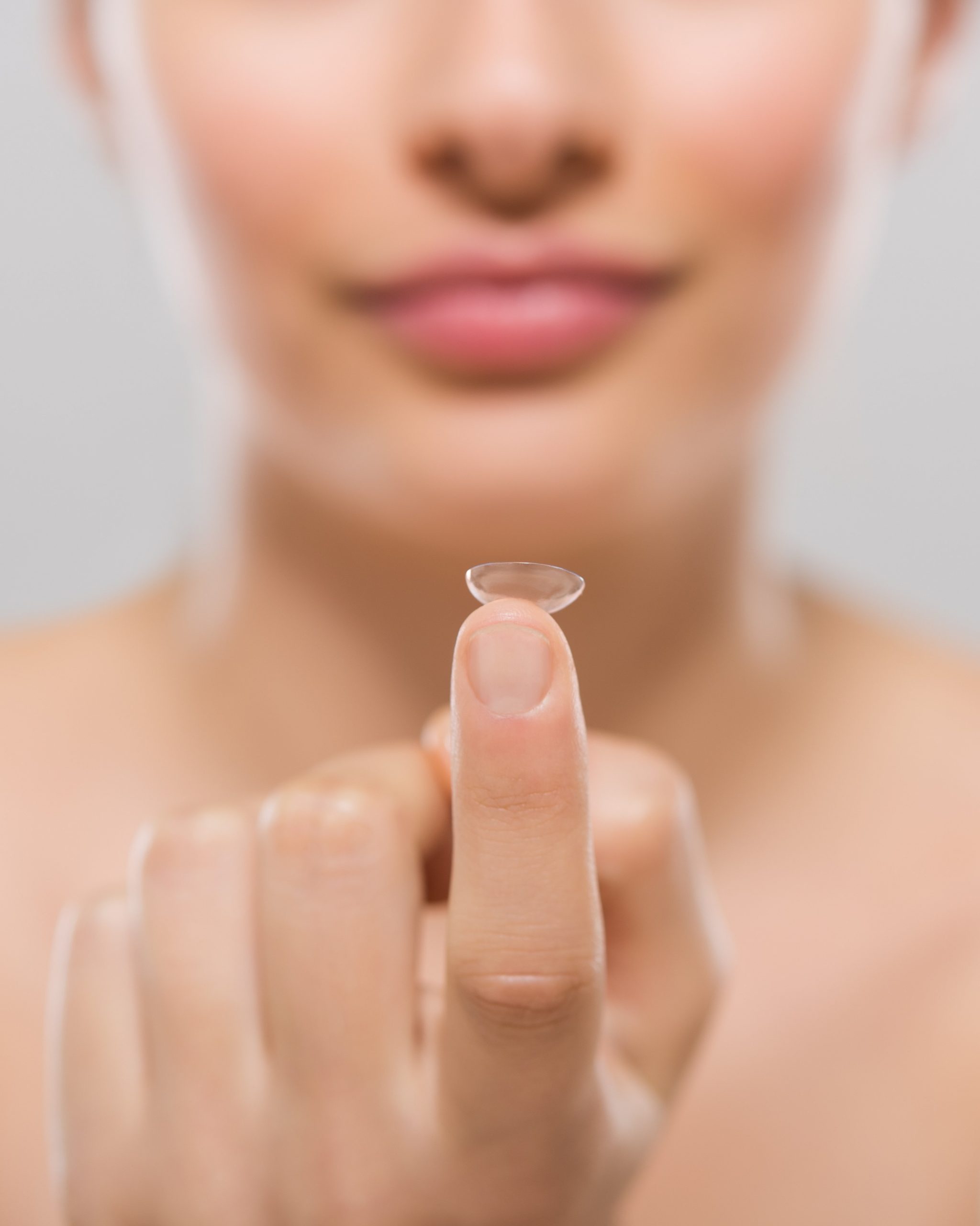 Close up of woman holding a contact lens scaled