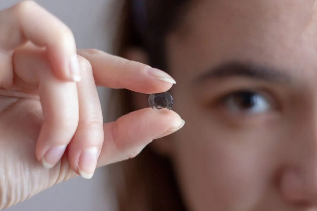 girl holding up contact lens