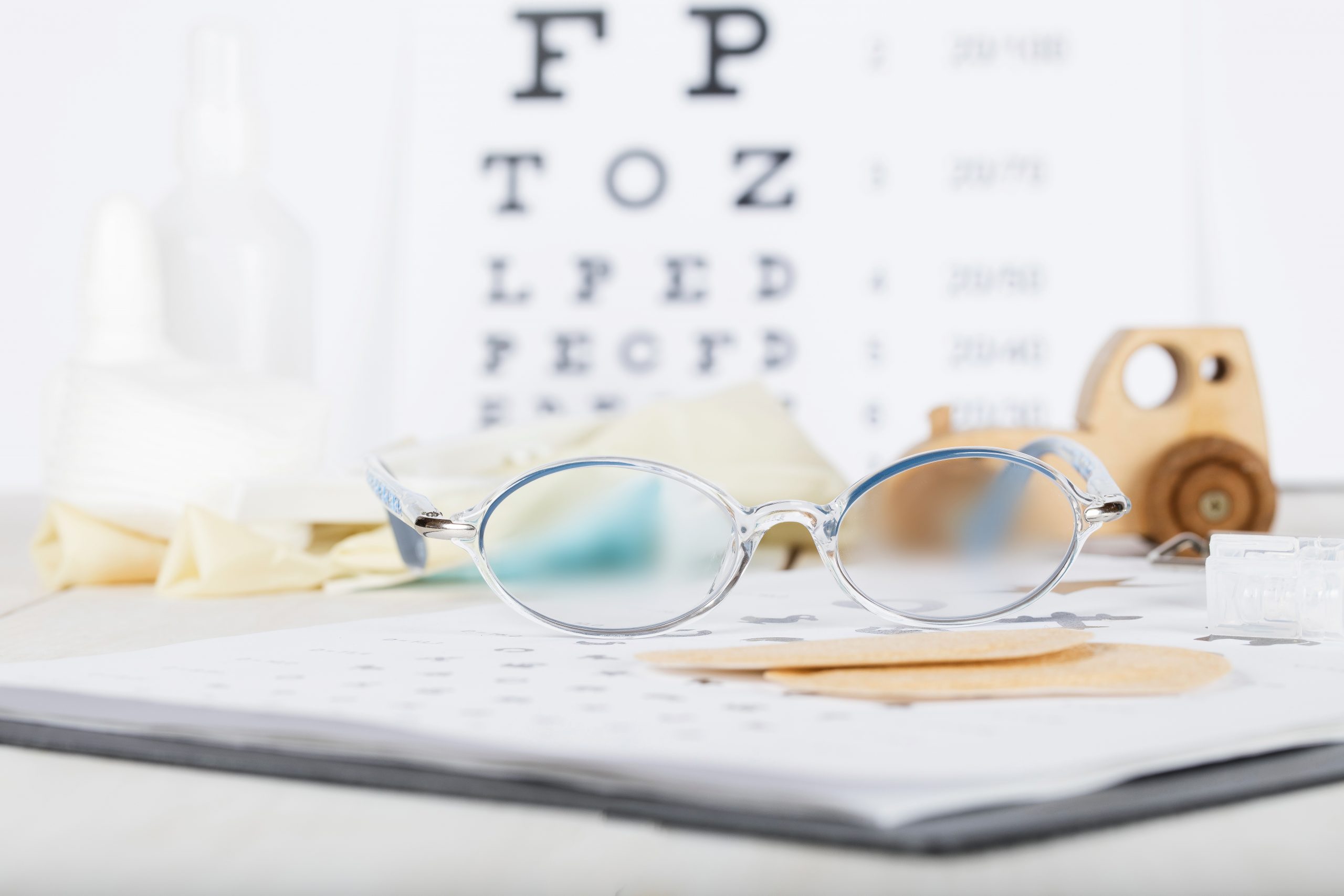 Eyeglasses for children on a eye chart close to eye pads.