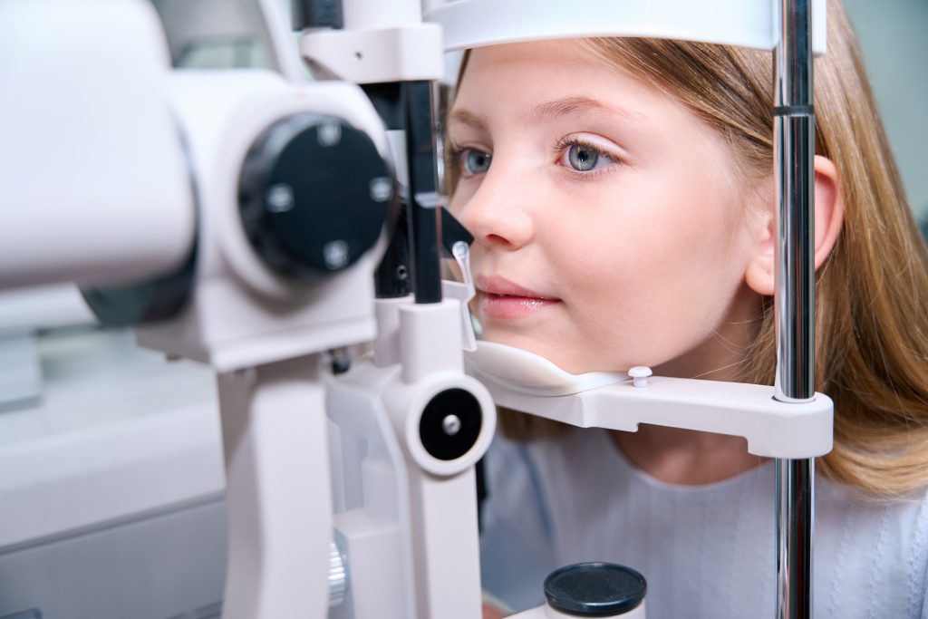 young girl behind slit lamp