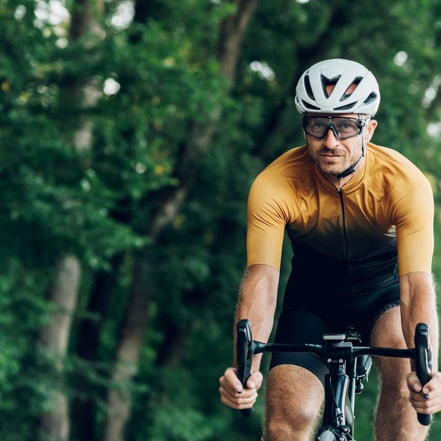 Athletic man in sport clothes riding a bike in the nature