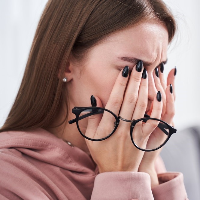 Woman rubbing dry irritated eyes