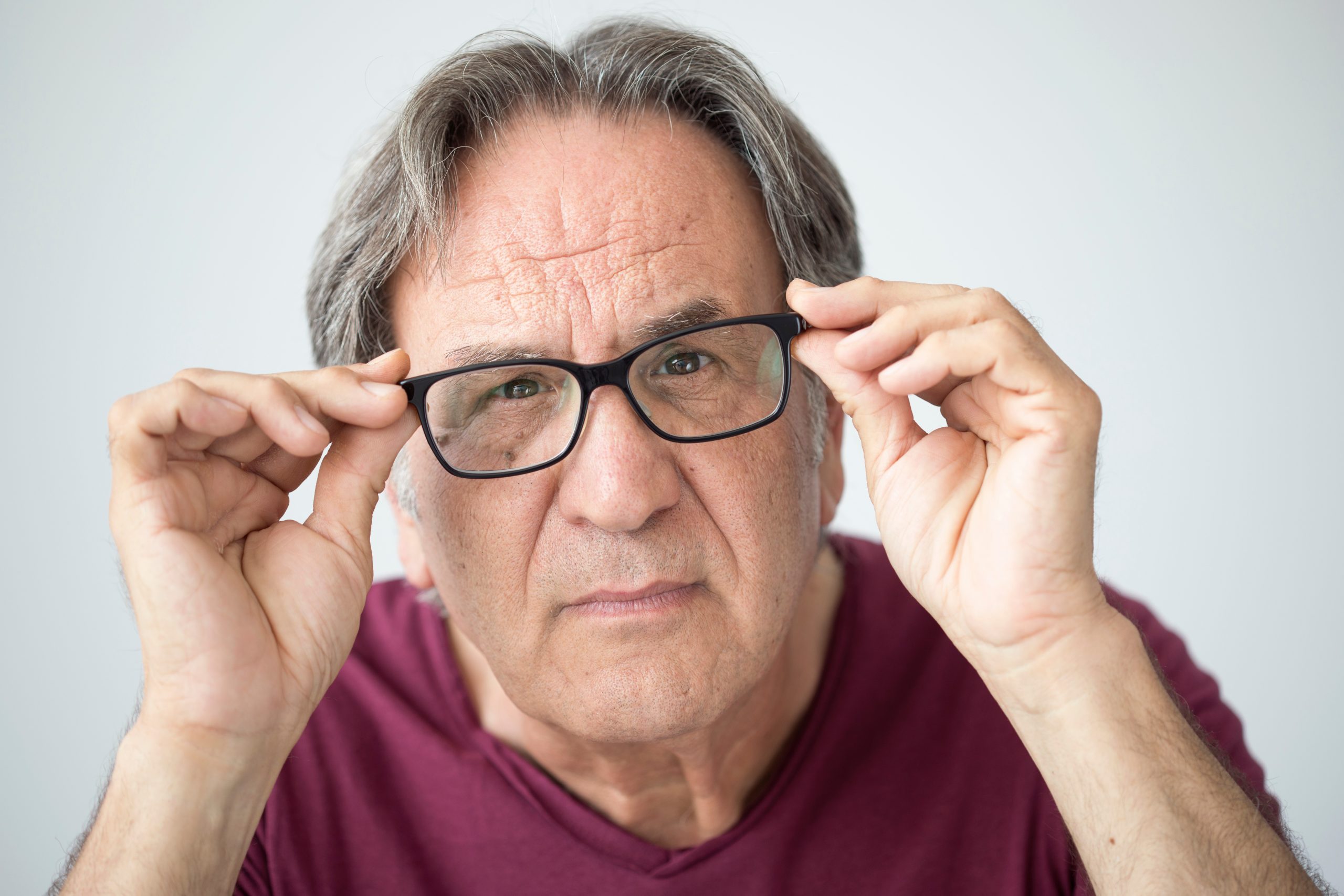 senior man cant see properly holding glasses