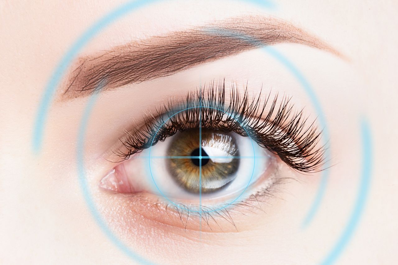 Refractive surgery, eye laser surgery concept. Female eye close up with blue laser rays