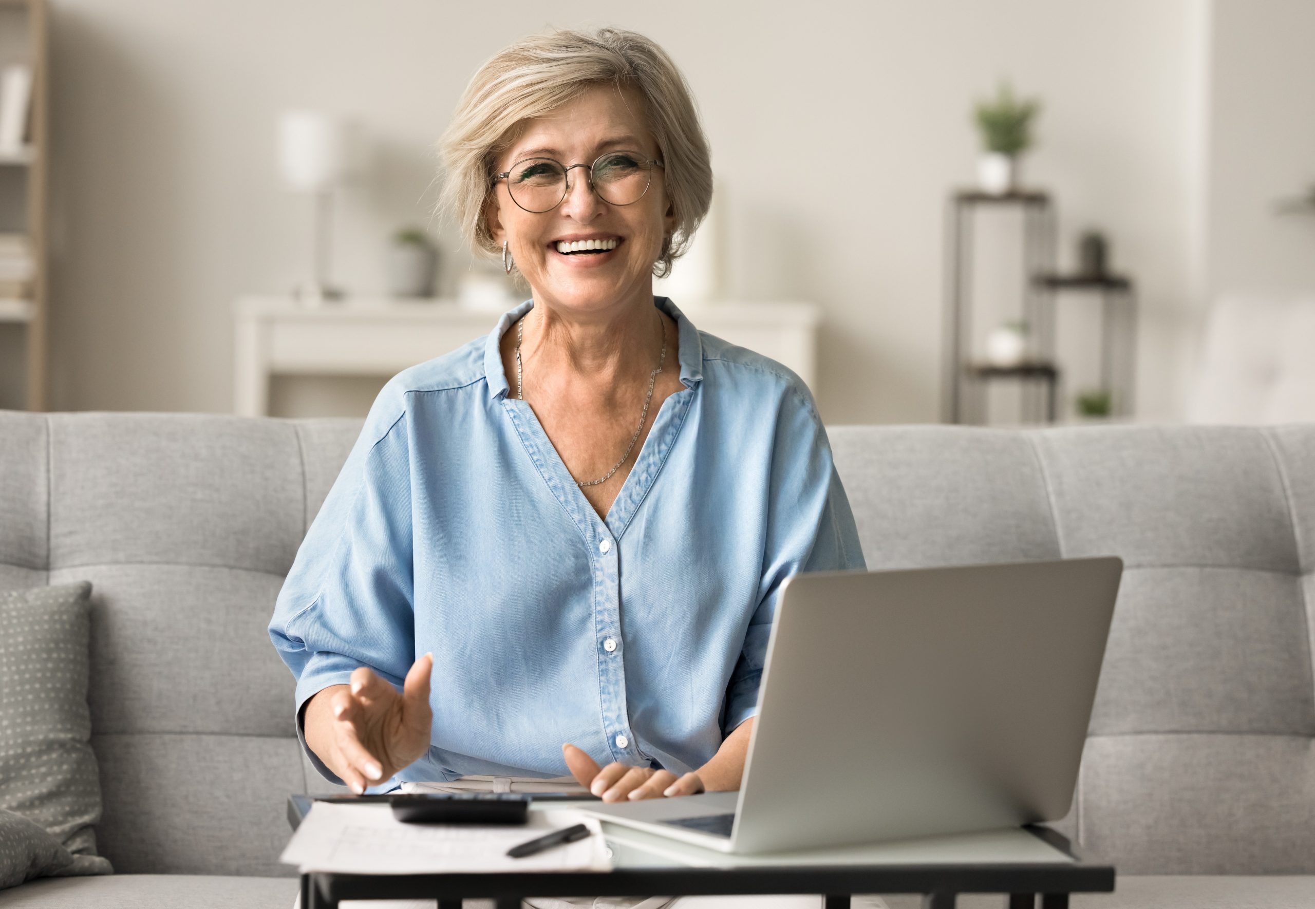 Happy mature old woman in stylish glasses enjoying financial success