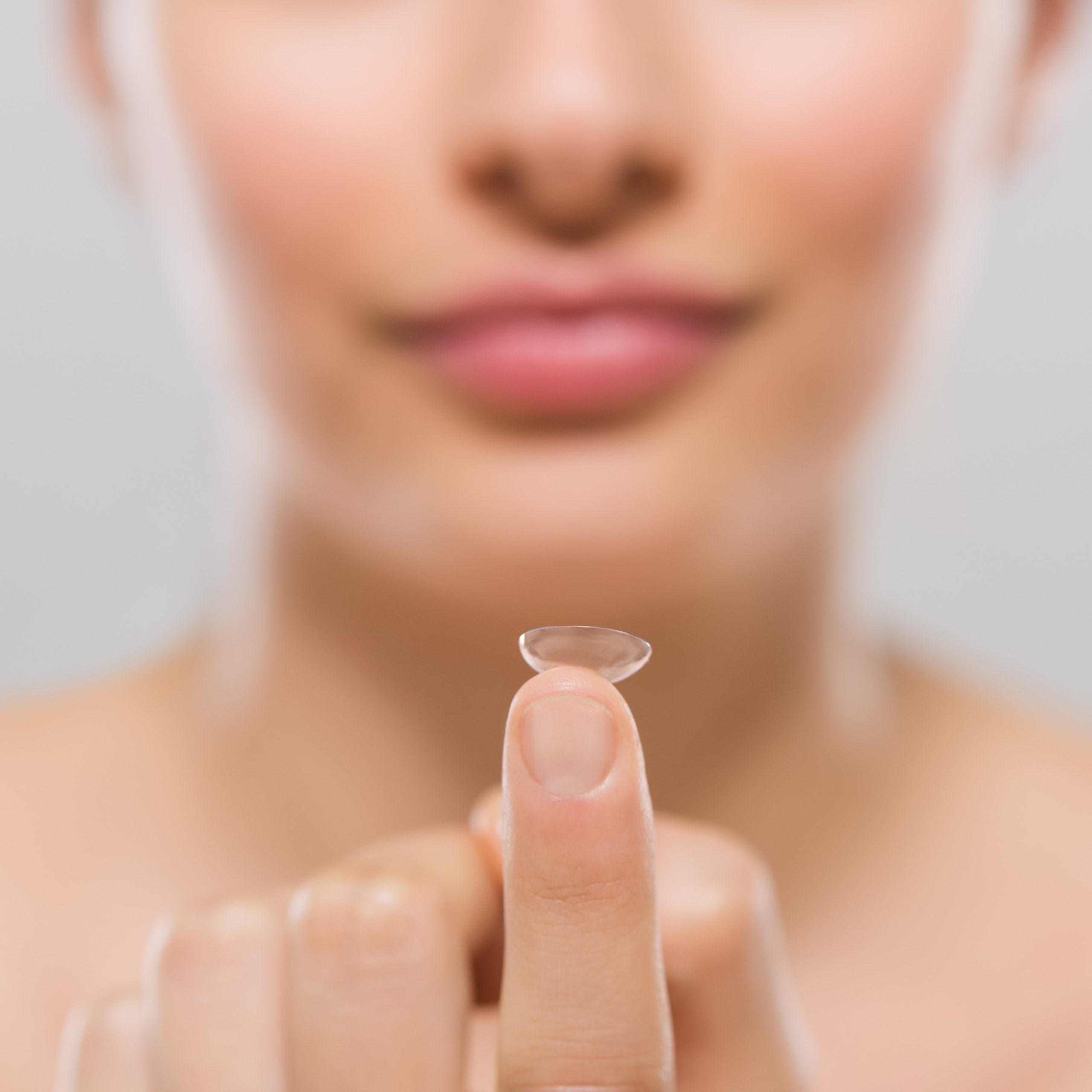 Woman holding contact lens