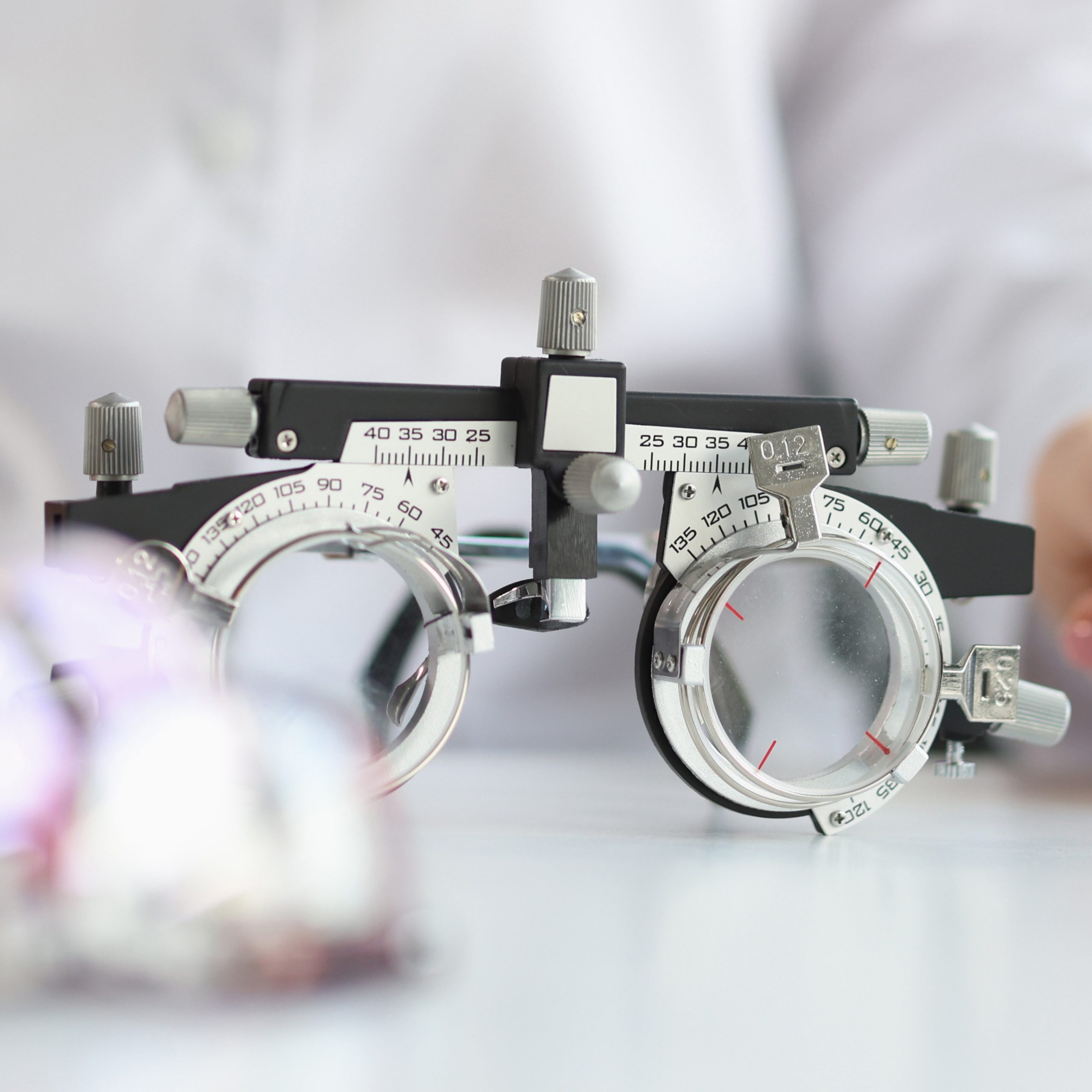 Glasses for checking vision lying on table near doctor ophthalmologist closeup