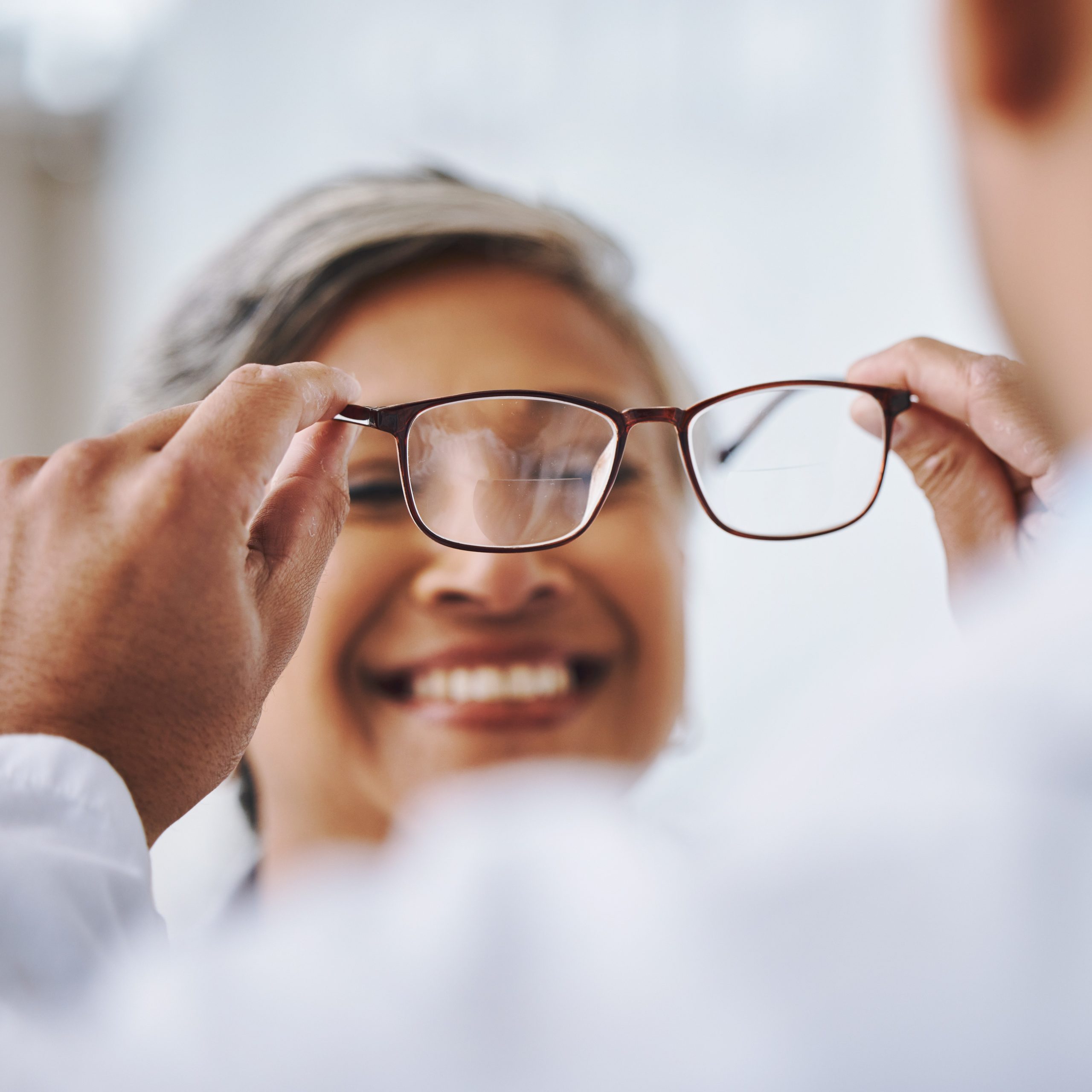 Optometrist putting on eyeglasses