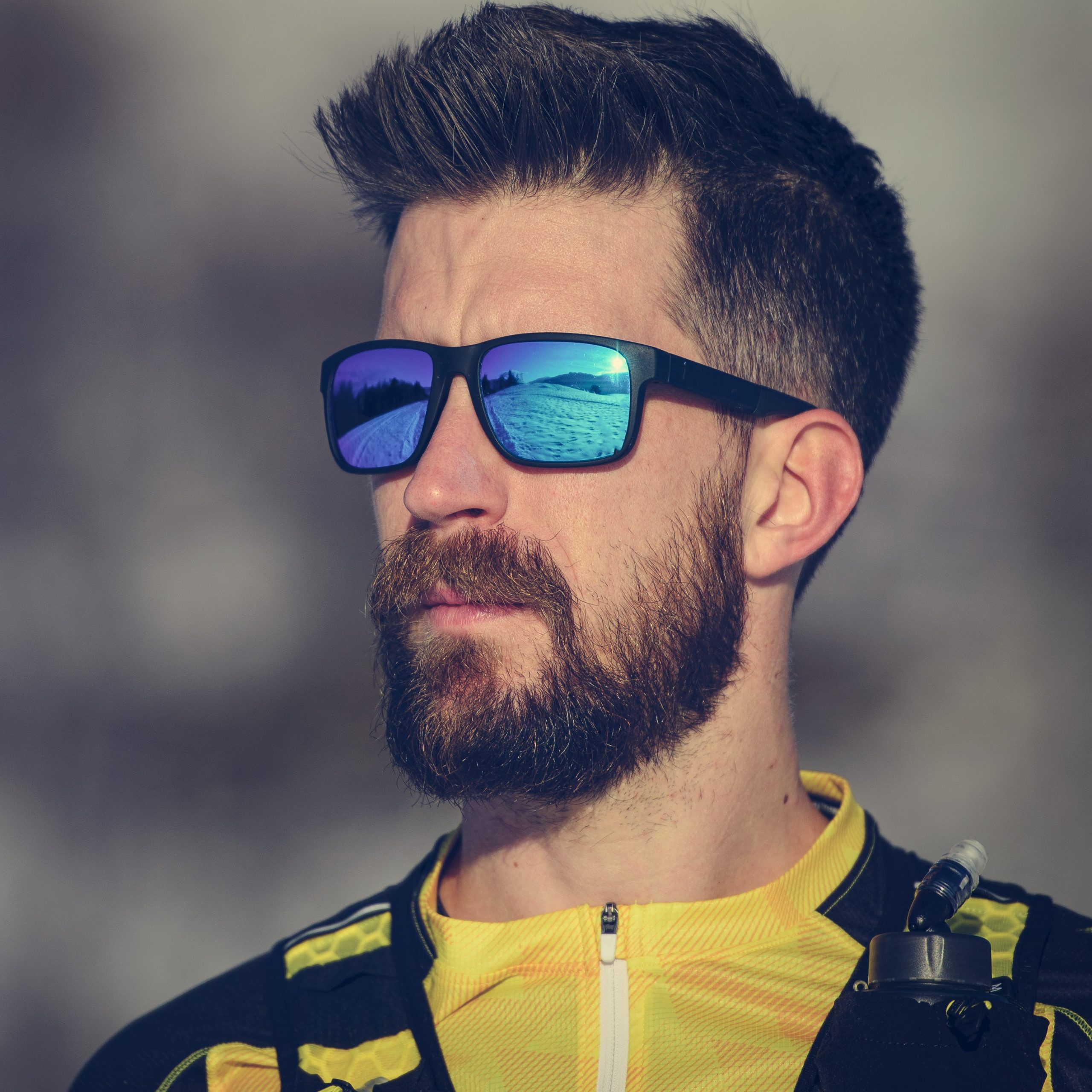 Portrait of young athlete man with beard and sports glasses